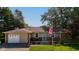 Charming single-story home featuring a cozy front porch, an attached garage, and a neatly maintained front lawn at 453 N 275 E, Columbus, IN 47203