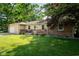 Traditional single-story home with brick and siding, attached garage and a well-manicured lawn with shade trees at 453 N 275 E, Columbus, IN 47203