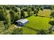 Aerial view of an outbuilding with a concrete driveway and fenced in area, nestled in a treed lot at 453 N 275 E, Columbus, IN 47203