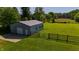 Outbuilding features a garage door and fenced area with a wide expanse of green lawn at 453 N 275 E, Columbus, IN 47203