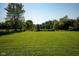 Lush green lot surrounded by mature trees, offering privacy and a serene setting for your new home at 453 N 275 E, Columbus, IN 47203