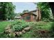 A beautifully landscaped backyard featuring a brick patio, sunroom, and lush greenery, perfect for relaxation at 46 Hawthorne Ct, Carmel, IN 46033