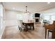 This dining room features hardwood floors, wainscoting, and a stylish chandelier, complemented by an inviting fireplace at 46 Hawthorne Ct, Carmel, IN 46033