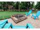 A beautiful stone fire pit surrounded by Adirondack chairs on a paved patio, perfect for entertaining guests at 46 Hawthorne Ct, Carmel, IN 46033