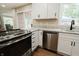 Modern kitchen with white cabinets, stainless steel appliances and view to the patio at 46 Hawthorne Ct, Carmel, IN 46033