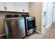 Modern laundry room featuring front load washer and dryer and custom cabinets on hardwood floors at 46 Hawthorne Ct, Carmel, IN 46033
