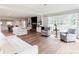 Bright open-concept living area with large windows, fireplace, hardwood floors, and a view into the dining room at 46 Hawthorne Ct, Carmel, IN 46033