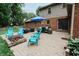 A large brick patio with outdoor seating, a fire pit, and a view of the home's exterior and lush backyard at 46 Hawthorne Ct, Carmel, IN 46033