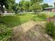 Well-kept backyard with a white fence, healthy lawn, and bricked patio space surrounded by plants at 472 N 17Th St, Noblesville, IN 46060