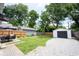 Spacious backyard with a lush lawn, patio area, shed and a detached garage with gravel driveway at 4927 Caroline Ave, Indianapolis, IN 46205