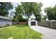 Spacious backyard featuring a lush lawn, fenced in area, and detached garage with gravel driveway at 4927 Caroline Ave, Indianapolis, IN 46205