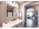 Bright bathroom featuring a modern sink, vanity, and framed mirror with a view into the next room at 4927 Caroline Ave, Indianapolis, IN 46205