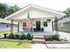Charming home featuring a quaint covered porch, adorned with an American flag and seating area at 4927 Caroline Ave, Indianapolis, IN 46205