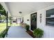 Covered front porch featuring white paneling, black door, and wicker seating at 4927 Caroline Ave, Indianapolis, IN 46205
