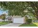 Attached two-car garage with a brick facade, mature tree and manicured landscaping at 5269 Deer Creek Dr, Indianapolis, IN 46254