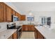Well-lit kitchen with wood cabinets, white countertops, stainless steel appliances, and a view to the yard at 5269 Deer Creek Dr, Indianapolis, IN 46254