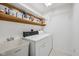 Functional laundry area with a utility sink, shelving, and a washer-dryer setup at 5269 Deer Creek Dr, Indianapolis, IN 46254