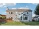 View of the back of the home, featuring a deck and sunroom addition under a cloudy blue sky at 5269 Deer Creek Dr, Indianapolis, IN 46254