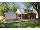 Brick home's backyard featuring a patio, lush greenery, and partial shade, great for outdoor enjoyment at 5460 N Park Dr, Indianapolis, IN 46220