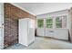 Bright, brick-walled sunroom with a fridge and large windows, ideal for indoor-outdoor living at 5460 N Park Dr, Indianapolis, IN 46220