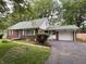Charming brick home with a well-maintained lawn, attached garage, and mature trees at 5460 N Park Dr, Indianapolis, IN 46220