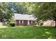 Attractive brick home with mature trees and a well-manicured lawn, providing a serene setting at 5460 N Park Dr, Indianapolis, IN 46220