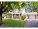 Inviting brick home with an attached garage, green roof, and a lush front lawn, offering comfortable living at 5460 N Park Dr, Indianapolis, IN 46220