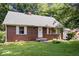 Charming brick home with a green roof, white trim, and a well-maintained lawn, showcasing curb appeal at 5460 N Park Dr, Indianapolis, IN 46220