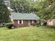 Classic brick home with a green roof and mature landscaping at 5460 N Park Dr, Indianapolis, IN 46220