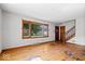 Bright living room with hardwood floors, large window, and wood staircase at 5460 N Park Dr, Indianapolis, IN 46220