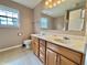 Bathroom featuring a double sink vanity with wood cabinets, a large mirror, and neutral wall color at 5571 Auburndale Dr, Bargersville, IN 46106