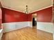 Dining room with hardwood floors, wainscoting, and vibrant red walls at 5571 Auburndale Dr, Bargersville, IN 46106