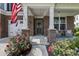 Charming front porch with brick accents, an American flag, and cozy seating area at 5917 Bartley Dr, Noblesville, IN 46062