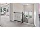 Upstairs hallway with carpeted floors, a decorative banister, natural light, and views of bedrooms at 5917 Bartley Dr, Noblesville, IN 46062