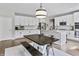 Bright kitchen with large island, white cabinetry, stainless steel appliances, and dark countertop at 5917 Bartley Dr, Noblesville, IN 46062
