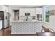 Bright kitchen with large island, white cabinetry, stainless steel appliances, and dark countertop at 5917 Bartley Dr, Noblesville, IN 46062
