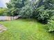 Lush backyard featuring a mix of lawn and natural foliage, with mature trees creating privacy at 5938 Tybalt Ln, Indianapolis, IN 46254