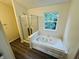 Bright bathroom featuring a tub with jets next to a glass shower and a window with natural light at 5938 Tybalt Ln, Indianapolis, IN 46254