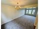 Dining area featuring plush carpeting and a chandelier, illuminated by natural light from large windows at 5938 Tybalt Ln, Indianapolis, IN 46254