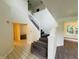Bright foyer features staircase with white railing, tile flooring, and access to living spaces at 5938 Tybalt Ln, Indianapolis, IN 46254