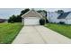 Attached garage with a white door, long driveway, and well-manicured landscaping at 5938 Tybalt Ln, Indianapolis, IN 46254