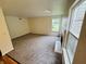 Cozy living room with a fireplace, gray carpeting, and plenty of natural light at 5938 Tybalt Ln, Indianapolis, IN 46254