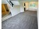 Open living area with gray carpeting, a staircase, and natural light at 5938 Tybalt Ln, Indianapolis, IN 46254