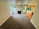 Comfortable living room featuring a fireplace, large windows, and plush neutral carpeting at 5938 Tybalt Ln, Indianapolis, IN 46254