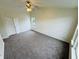 Generously-sized main bedroom featuring carpet, ceiling fan, bright windows, and double door closet at 5938 Tybalt Ln, Indianapolis, IN 46254