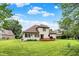 Spacious backyard with a well-manicured lawn, wooden deck, and mature trees, ideal for Gathering gatherings and relaxation at 6050 Acorn Dr, Columbus, IN 47201