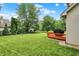 Well-maintained backyard with lush greenery, a wooden deck, and mature trees, offering a serene outdoor space at 6050 Acorn Dr, Columbus, IN 47201