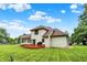 Expansive backyard featuring a wooden deck, lush green lawn, and mature trees, perfect for outdoor enjoyment at 6050 Acorn Dr, Columbus, IN 47201