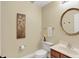 Well-lit powder room showcases a round mirror, vanity, and toilet, providing a fresh and functional space at 6050 Acorn Dr, Columbus, IN 47201