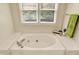 Relaxing bathroom with a soaking tub, tile surround, and a view from the window at 6050 Acorn Dr, Columbus, IN 47201